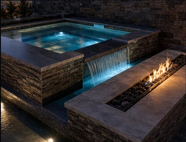 Custom hot tub and spa with stonework, lighting, and fire detail.