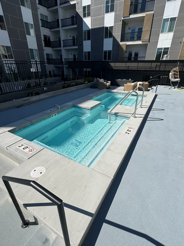 Finished spa with entry rails, steps, and seating at the Millcreek project.
